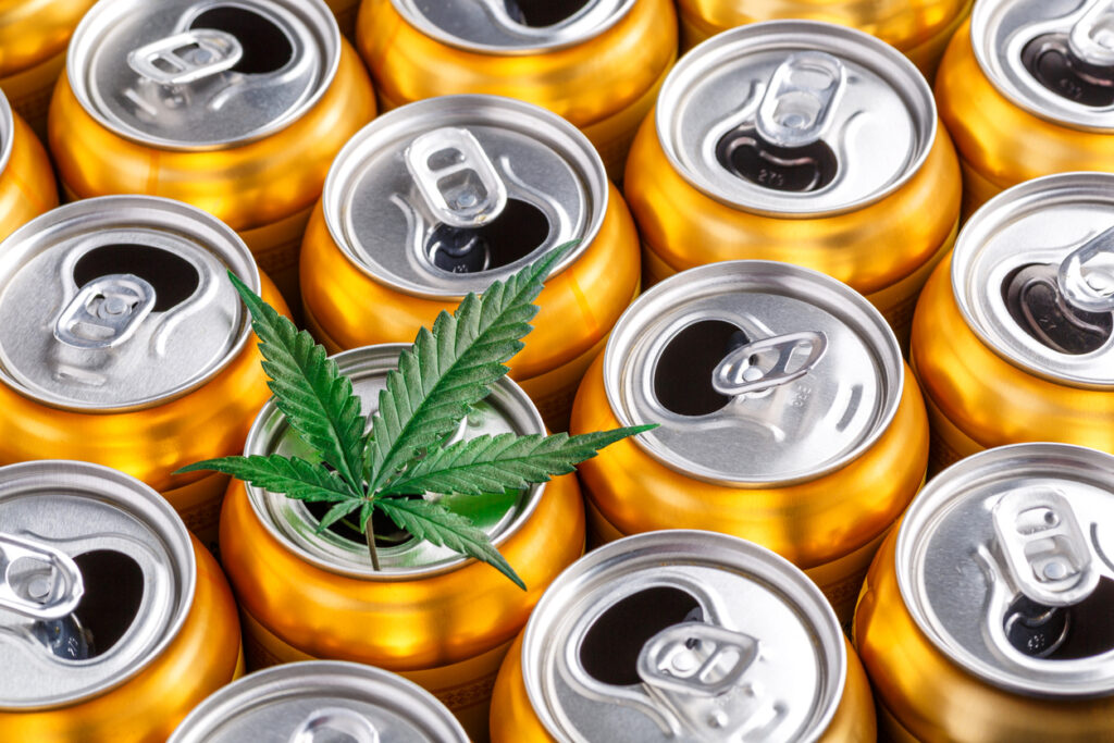 Cannabis leaf on soda cans, top view.