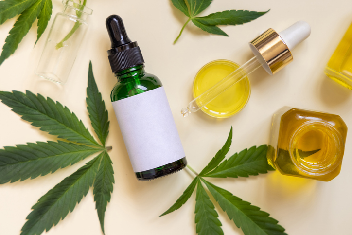 Cannabis leaves with oil bottles and dropper