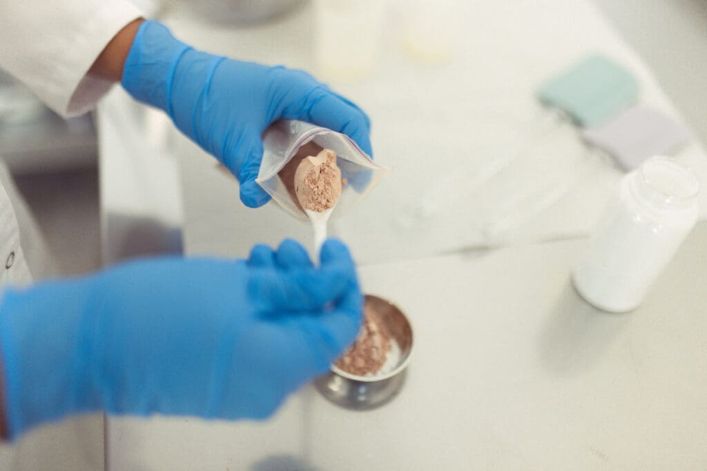 Scientist measuring powder in laboratory with gloves