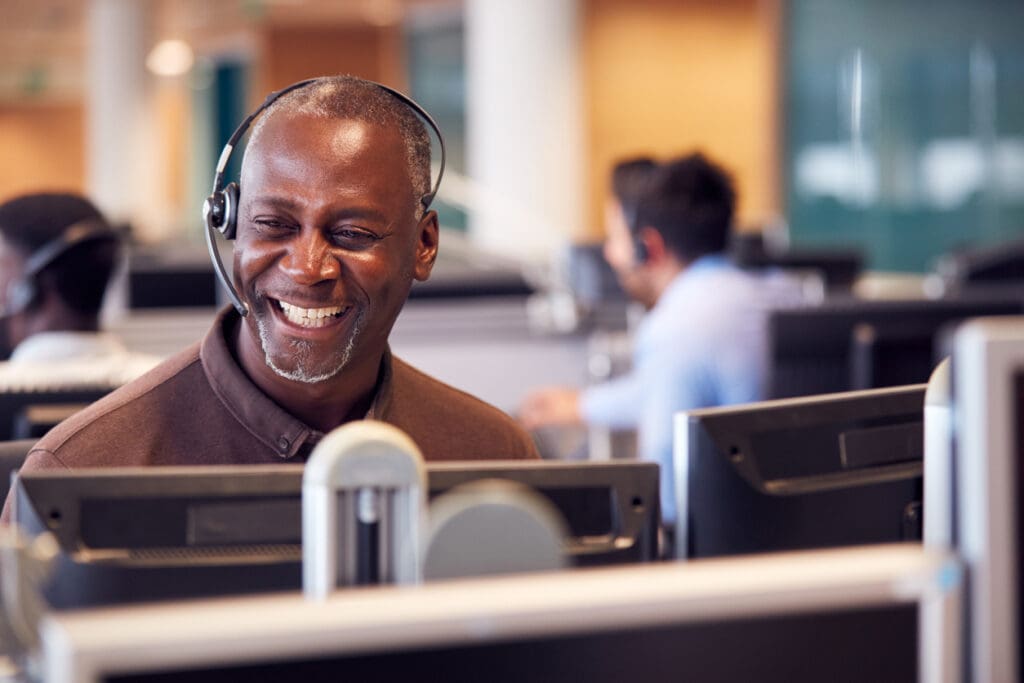 Smiling call center employee with headset on.