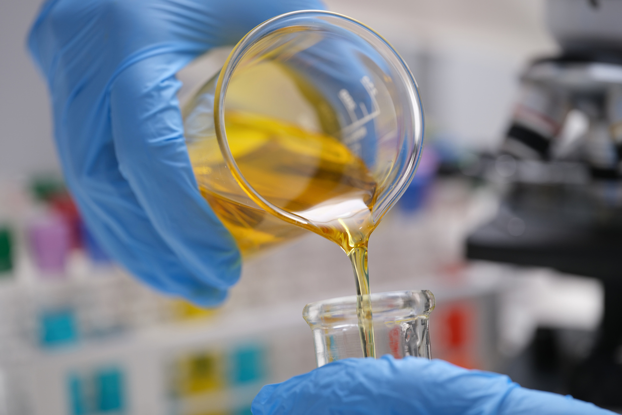 Pouring and mixing chemicals closeup. Laboratory and scientific experiments. Petroleum formulation of chemicals for medical research.