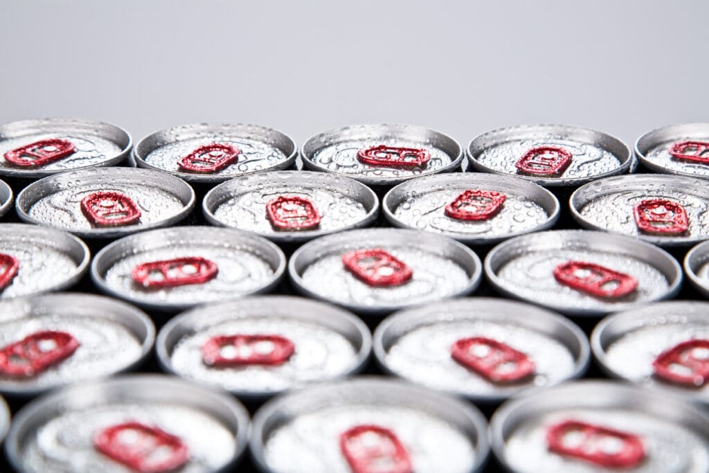 Close-up of opened soda can tops in rows
