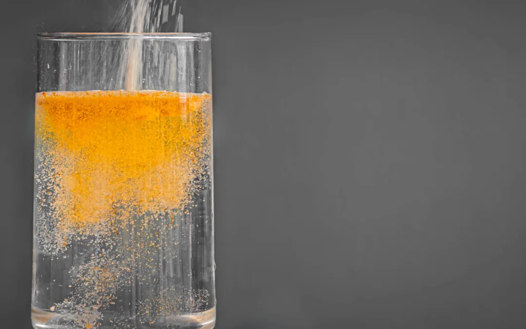 powdered drink mix pouring into glass of water