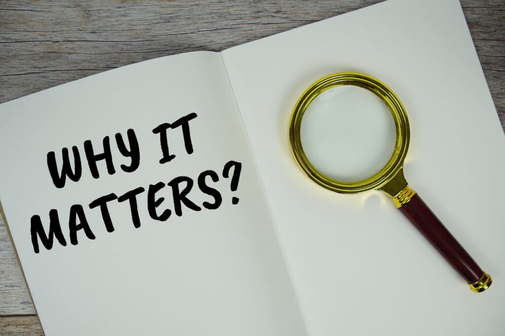 Why it matters? text on notebook page with magnifying glass top view on wooden background